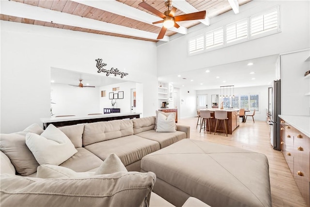 living room with wood ceiling, ceiling fan, beamed ceiling, and light wood-type flooring