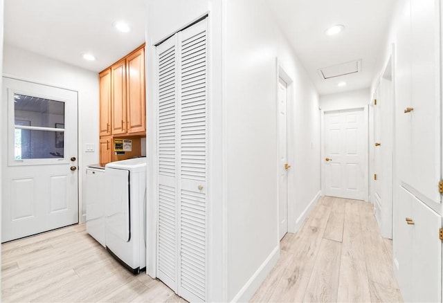 washroom featuring light hardwood / wood-style floors, cabinets, and washing machine and dryer