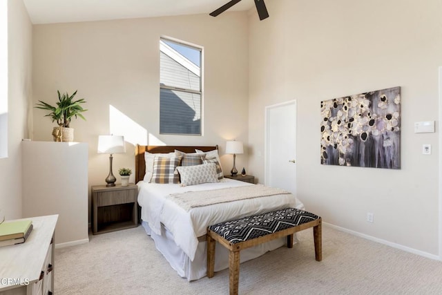 carpeted bedroom with ceiling fan and high vaulted ceiling