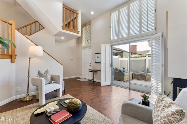 living room featuring dark wood-type flooring and a towering ceiling