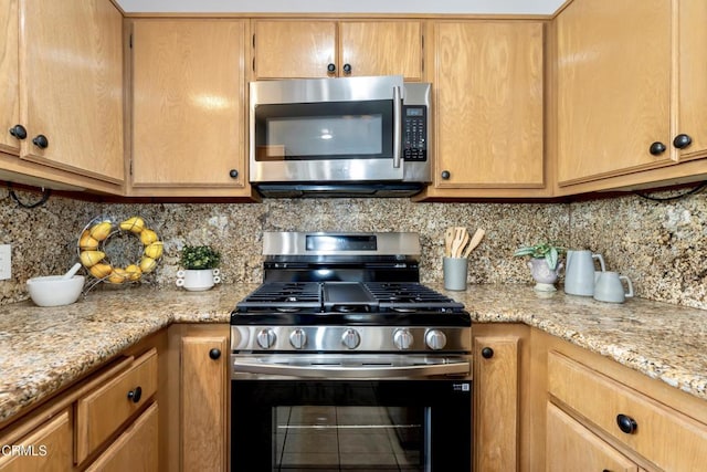 kitchen with tasteful backsplash, light stone countertops, and stainless steel appliances