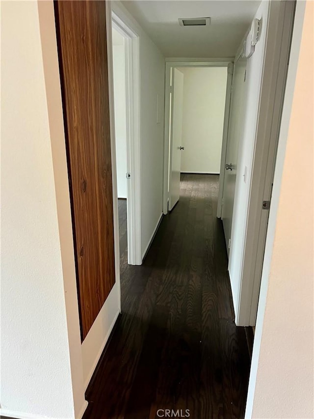 hallway with dark hardwood / wood-style flooring