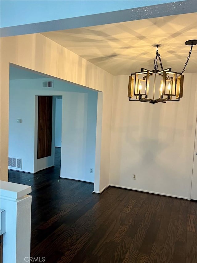 unfurnished dining area featuring dark hardwood / wood-style flooring and a chandelier