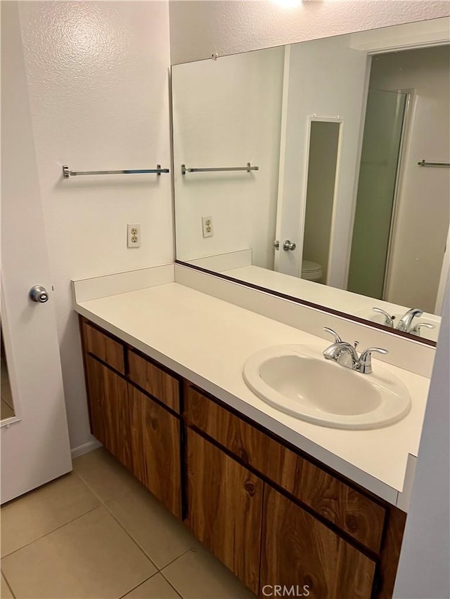 bathroom with vanity, tile patterned floors, and toilet