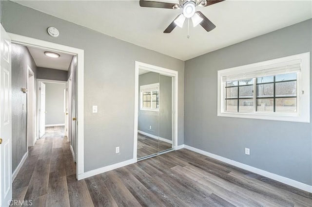 unfurnished bedroom featuring ceiling fan, dark wood-type flooring, and a closet