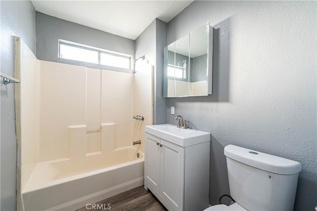 full bathroom featuring toilet, hardwood / wood-style flooring, shower / tub combination, and vanity