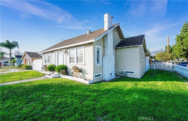 rear view of property featuring a lawn