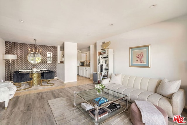 living room featuring sink, light hardwood / wood-style floors, and a chandelier