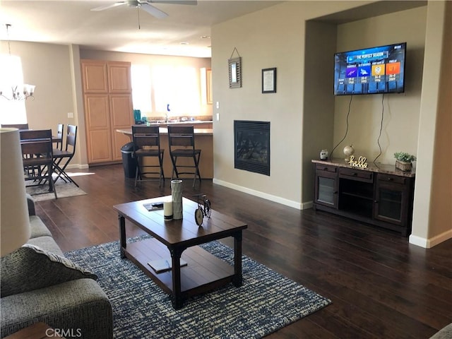 living room featuring dark hardwood / wood-style flooring and ceiling fan with notable chandelier