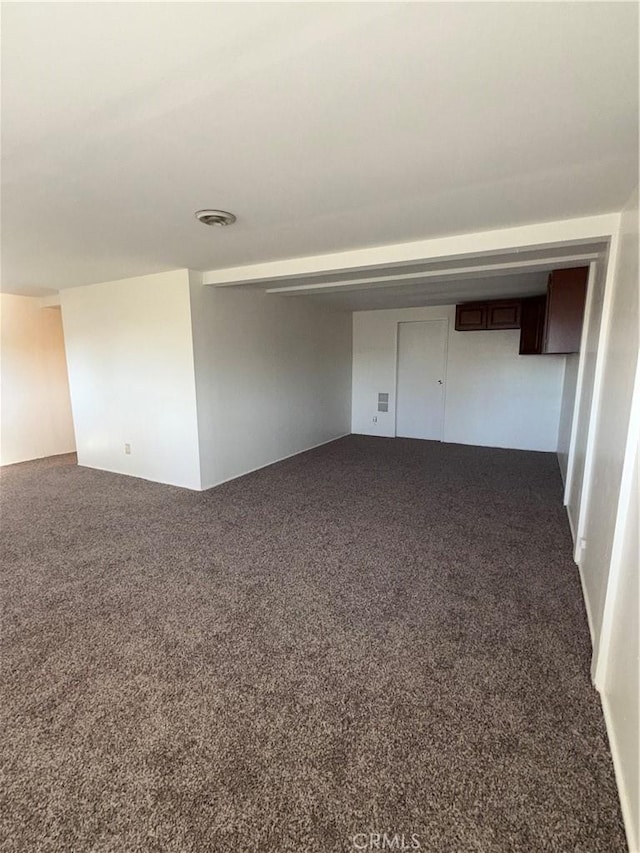 unfurnished room with dark colored carpet