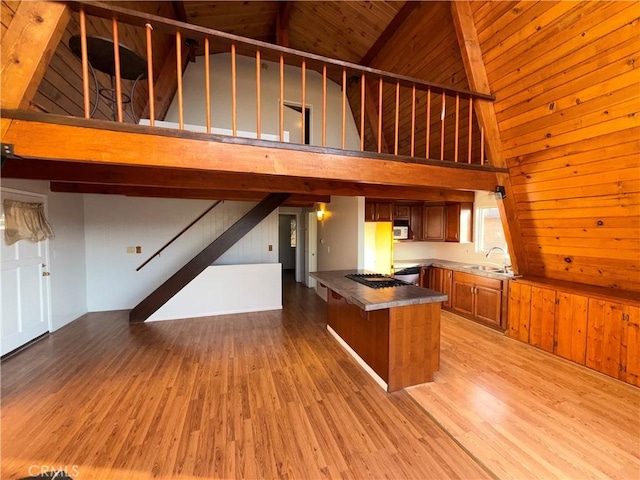 kitchen with light hardwood / wood-style floors, sink, high vaulted ceiling, and kitchen peninsula