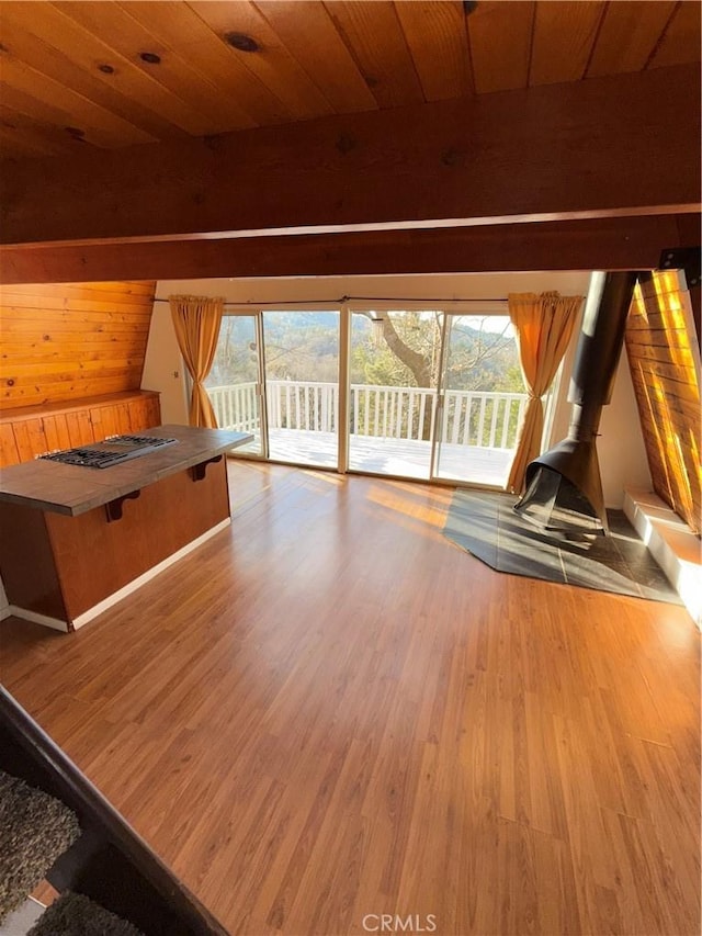 interior space with light hardwood / wood-style floors, wooden ceiling, and wooden walls