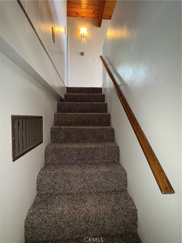 stairs featuring wood ceiling and beamed ceiling