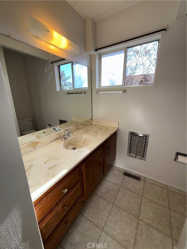 bathroom featuring vanity, toilet, and plenty of natural light