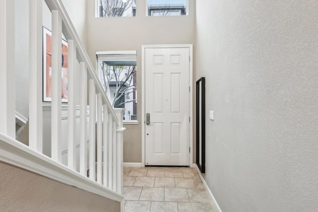 foyer with a high ceiling and light tile patterned floors