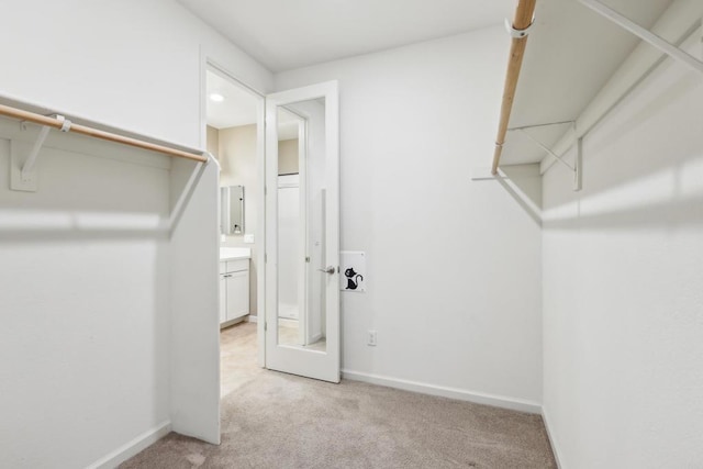 spacious closet featuring light colored carpet