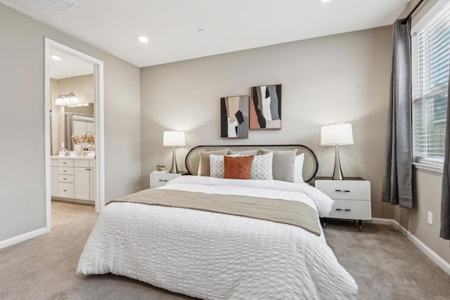 bedroom featuring light carpet and connected bathroom