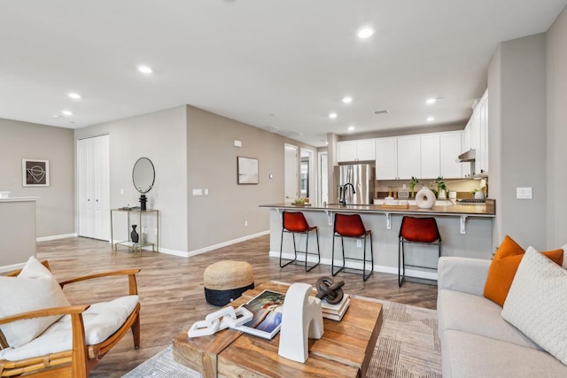 living room featuring light wood-type flooring and sink