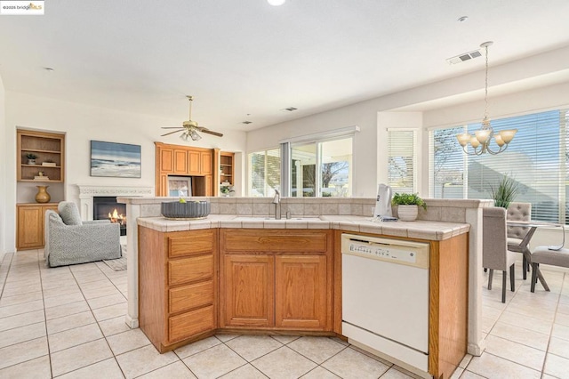 kitchen with sink, a center island, tile counters, and white dishwasher