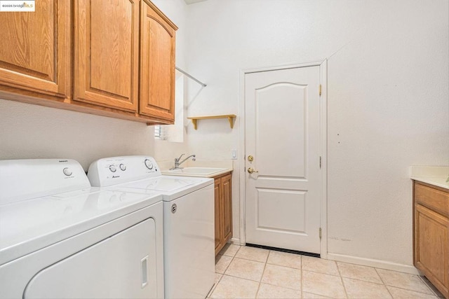 laundry area featuring sink, independent washer and dryer, cabinets, and light tile patterned floors