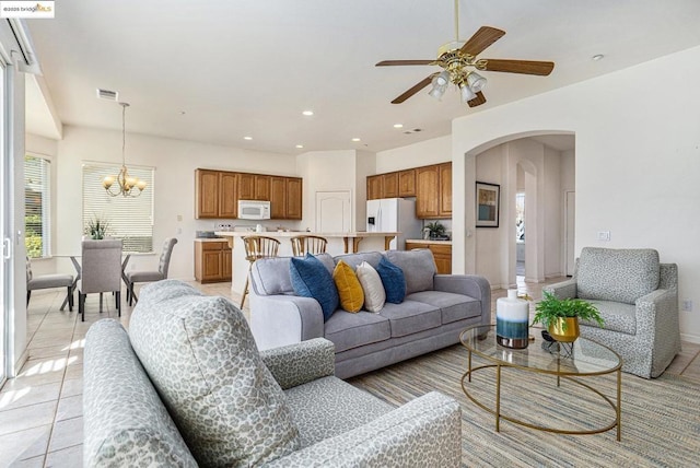 living room featuring ceiling fan with notable chandelier and light tile patterned floors