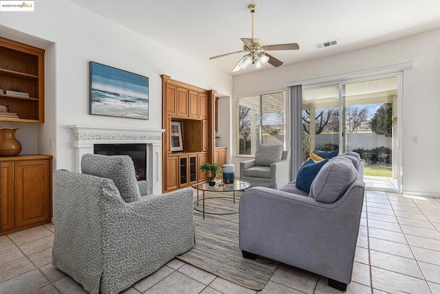 tiled living room featuring ceiling fan and a healthy amount of sunlight