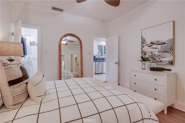 bedroom featuring ornamental molding, light hardwood / wood-style floors, ceiling fan, and ensuite bathroom