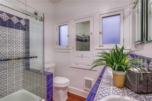 full bathroom with vanity, shower / bath combination with glass door, and toilet