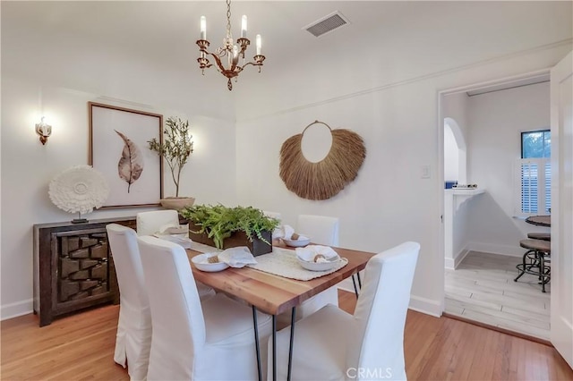 dining room featuring light hardwood / wood-style flooring and a notable chandelier