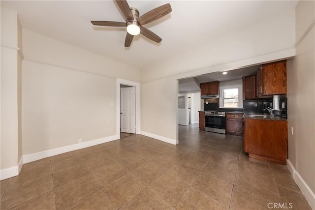 kitchen featuring decorative backsplash, sink, stainless steel stove, and ceiling fan