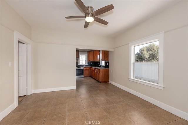 kitchen with stainless steel range oven, a healthy amount of sunlight, backsplash, and ceiling fan