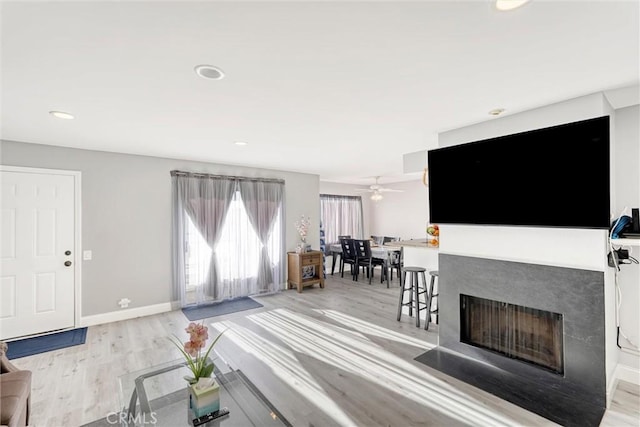 living room with light hardwood / wood-style flooring and ceiling fan