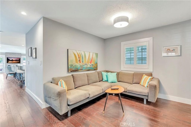 living room with dark wood-type flooring and a textured ceiling