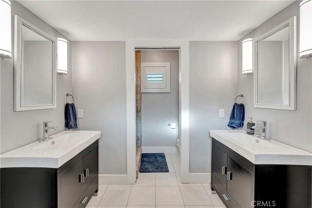 bathroom with vanity, toilet, tile patterned floors, and an enclosed shower