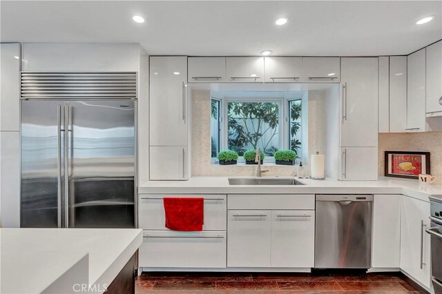 kitchen with sink, stainless steel appliances, and white cabinetry