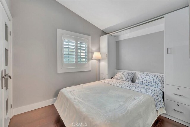 bedroom featuring dark hardwood / wood-style floors and lofted ceiling