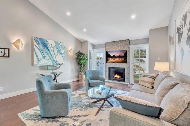 living room featuring a fireplace, hardwood / wood-style flooring, and lofted ceiling