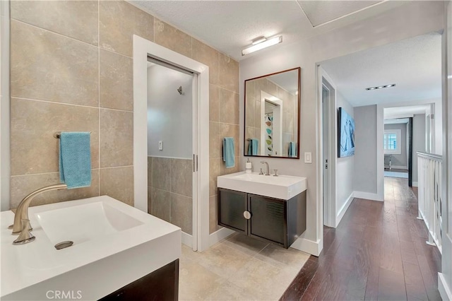 bathroom featuring vanity, hardwood / wood-style flooring, and tile walls