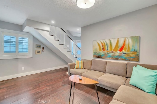 living room with wood-type flooring and a textured ceiling