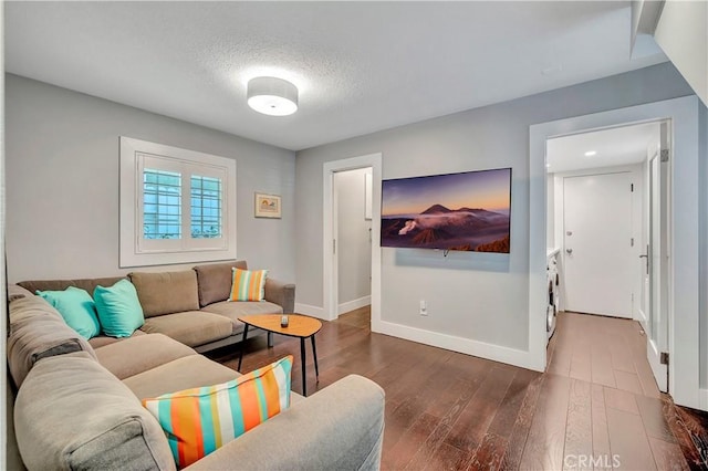 living room with dark wood-type flooring and a textured ceiling