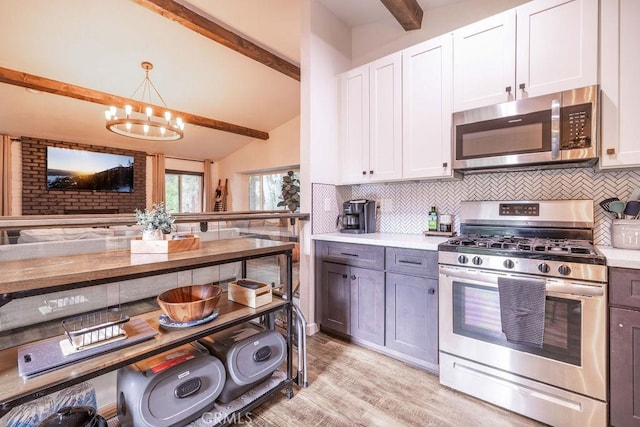 kitchen featuring white cabinetry, decorative backsplash, light wood-type flooring, pendant lighting, and stainless steel appliances