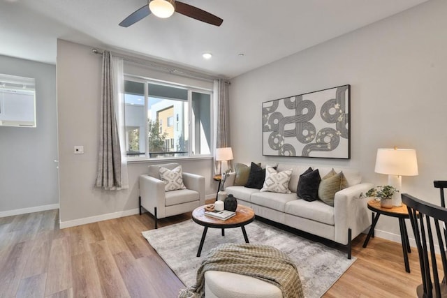 living room featuring ceiling fan and light hardwood / wood-style flooring