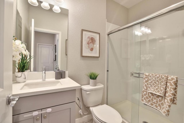 bathroom with vanity, an enclosed shower, and toilet