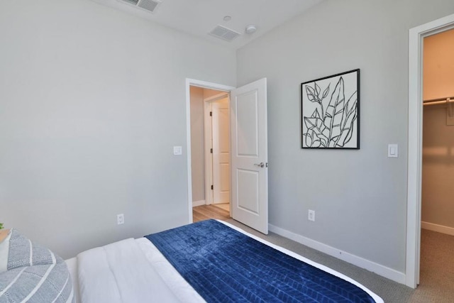 carpeted bedroom with a spacious closet and a closet