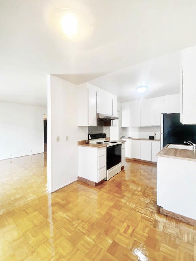 kitchen featuring light parquet floors, white cabinetry, stainless steel refrigerator, and white range with electric cooktop