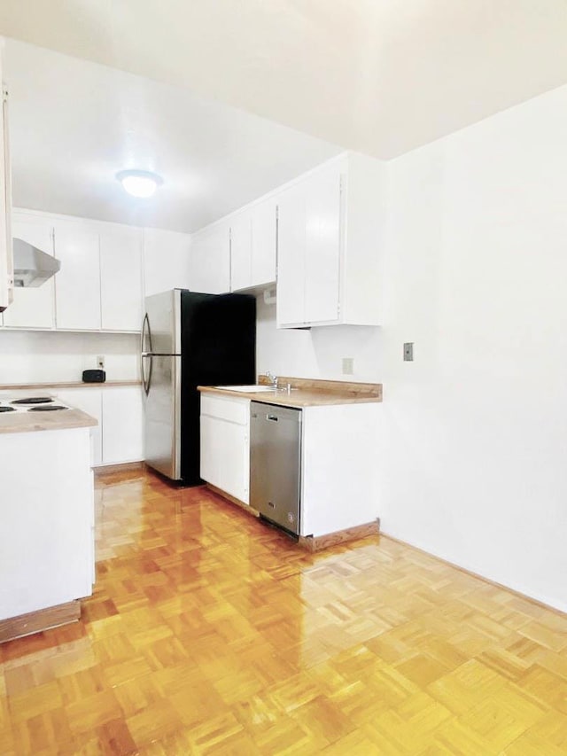 kitchen with white cabinets, appliances with stainless steel finishes, light parquet floors, and sink