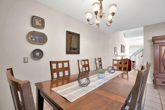 tiled dining area featuring a textured ceiling and an inviting chandelier