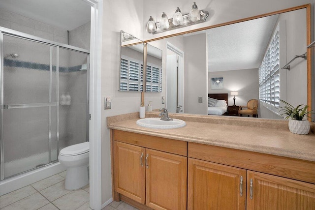 bathroom featuring vanity, toilet, a shower with shower door, and tile patterned flooring