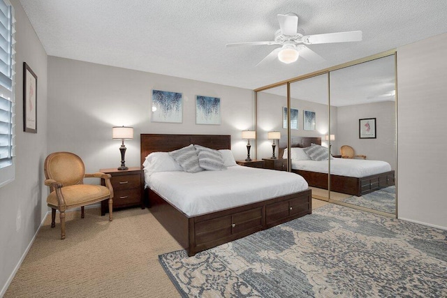 carpeted bedroom with ceiling fan, a textured ceiling, and a closet