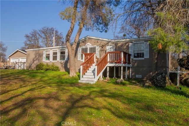 rear view of property with a wooden deck and a yard